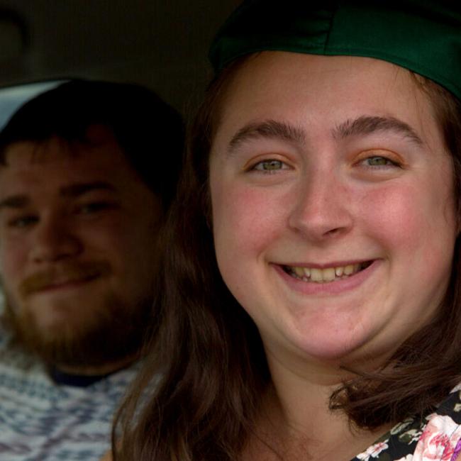 A graduate and guest attend the Norwich Campus's 2020 Drive-Thru Commencement from their vehicle