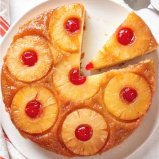 Round pineapple Upside Down Cake with Cherries and a slice cut out