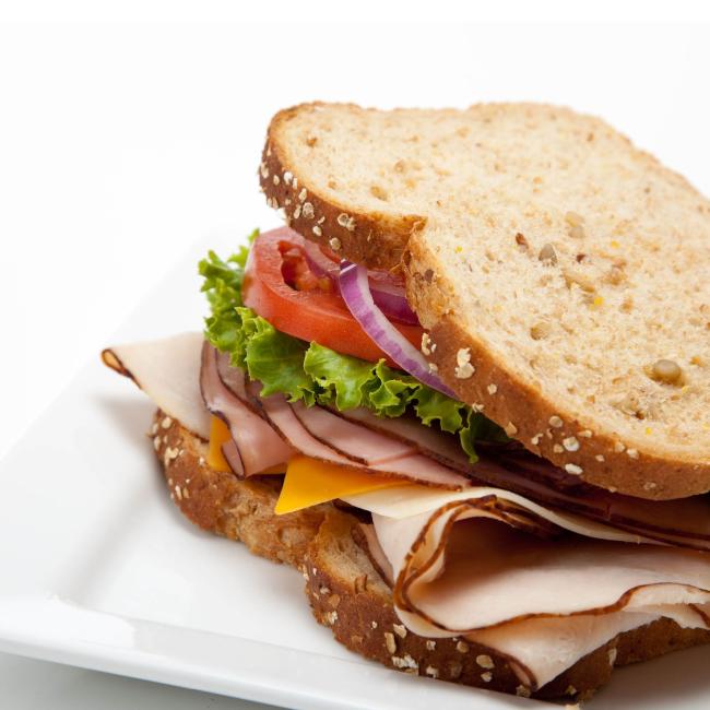 Turkey and cheese sandwich with lettuce, tomato and onion