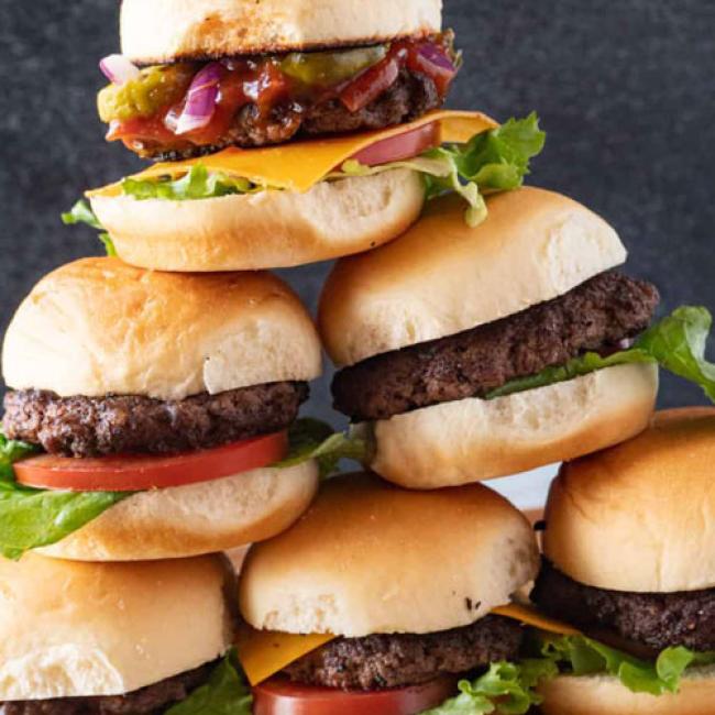 hamburger and cheeseburger sliders stacked in a pyramid