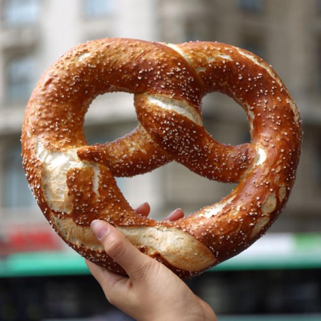 Hand holding up a large soft pretzel